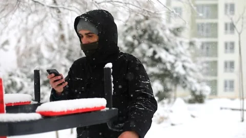 Young man using smartphone mobile in winter snowfall on sport area outside 스톡 동영상 167058541