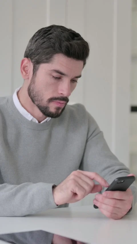 Young Man using Smartphone in Office, Vertical Video Vídeo Stock 339582236