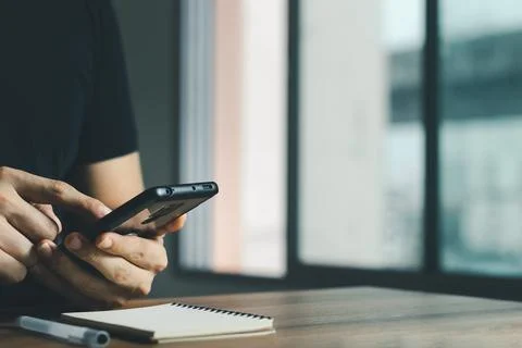 Young man using a smartphone at the office. Stock Photos