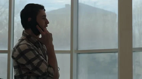 A young man using a smartphone to order food to your home by calling, in front Stock Footage 66184204