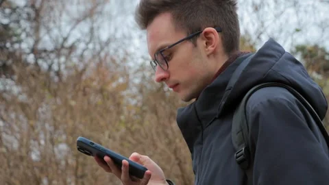Young man using smartphone outdoors Stock Footage 302803656