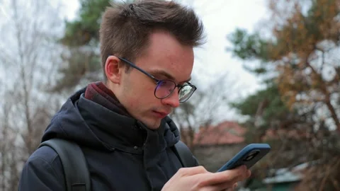 Young man using smartphone outdoors Stock Footage 302803657