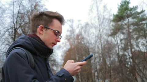 Young man using smartphone outdoors Stock Footage 302804140