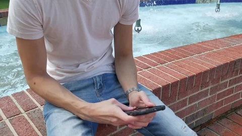 A young man using a smartphone outside (color graded) 스톡 동영상 75619694