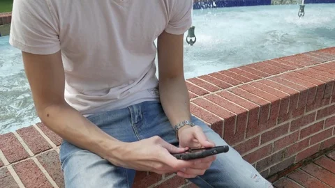 A young man using a smartphone outside 스톡 동영상 75619710