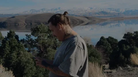 Young man using smartphone, overlooking scenic Topaz Lake... Stock Footage 328254626