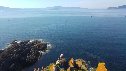 Young Man Using Smartphone by Scenic Coastal View Stock Footage 244940573