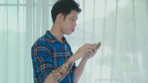 Young Man Using Smartphone by Sheer Curtain Stock Footage 314637568