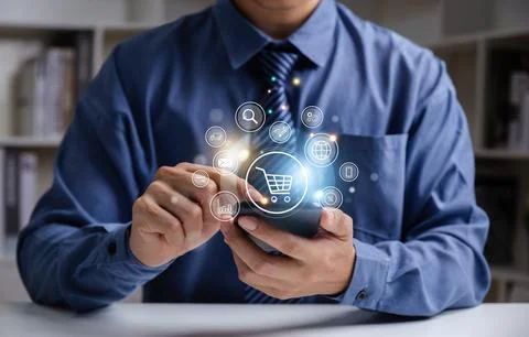 Young man using smartphone with shopping cart icon. Stock Photos