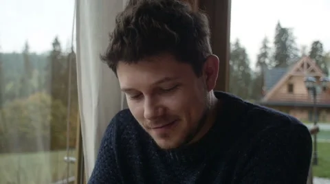 Young man using smartphone sitting in living room. 動画素材 56877679