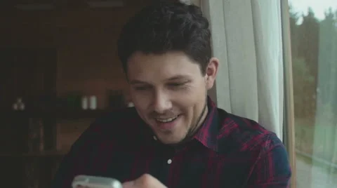 Young man using smartphone sitting in living room. Stock Footage 56878660