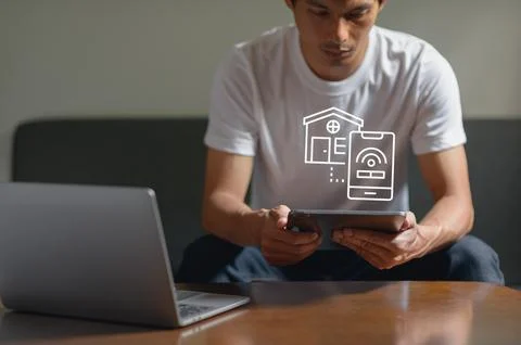 Young Man Using Smartphone with Smart Home and Wi-Fi Technology on Screen Stock Photos