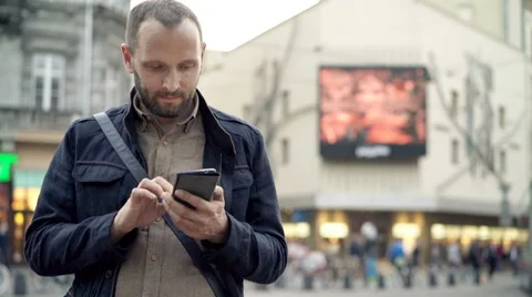 Young man using smartphone standing in city Stock Footage 64454743