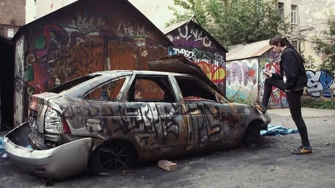 Young man using smartphone standing near crashed burned car. Urban lifestyle Video stock 80008481