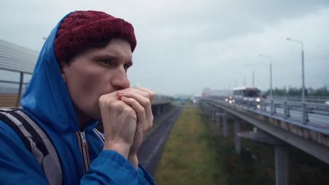 Young man using smartphone standing on road bridge. Road highway at background Stock Footage 80286533