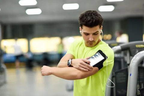 Young man using smartphone standing in the gym Stock Photos