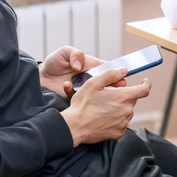 Young Man using a smartphone for texting and communication Stock-Fotos