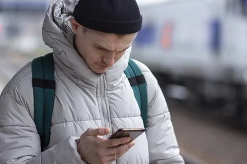 Young man using smartphone, texting, cheks the route of trip on google mapes Stock Photos