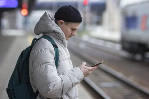 Young man using smartphone, texting, cheks the route of trip on google mapes Stock Photos