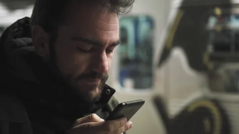 Young man using smartphone on train station at night slomo 100p Stock Footage 70633222