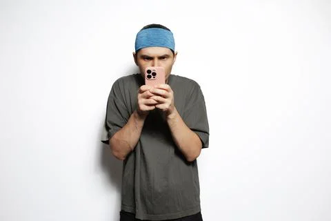Young man using smartphone very concentrated isolated on white background. Stock Photos