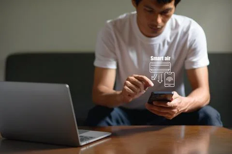 Young man using smartphone with virtual smart air technology projection at ho Stock Photos
