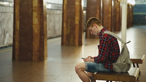 Young Man Using Smartphone Waiting for Subway Train at Metro Station Stock Footage 91457550
