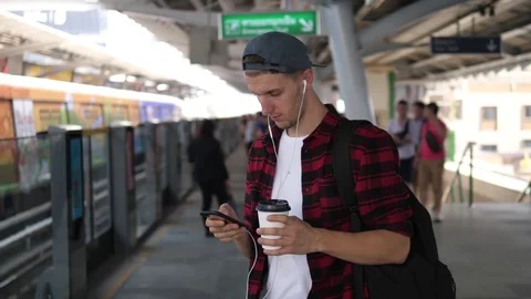 Young Man Using Smartphone While Waiting For Train On Station Platform Stock Footage 85021494