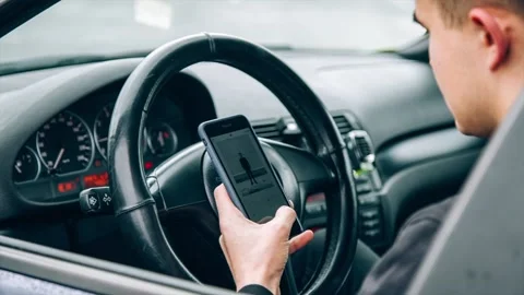 Young man using a smartphone while sitting inside a car Stock Footage 86132997