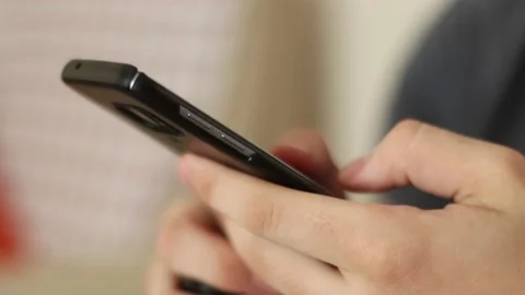 Young man using smartphone while doing homework. Stock Footage 131854392