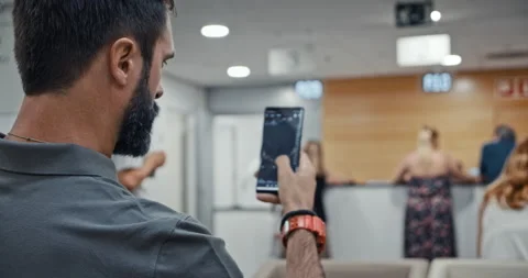 Young man using smartphone while sitting at hospital lobby waiting doctor visit Stock-Footage 143479117