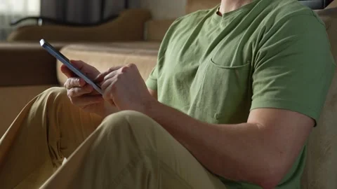 Young man using smartphone while sitting on the floor, close-up Stock Footage 272586336