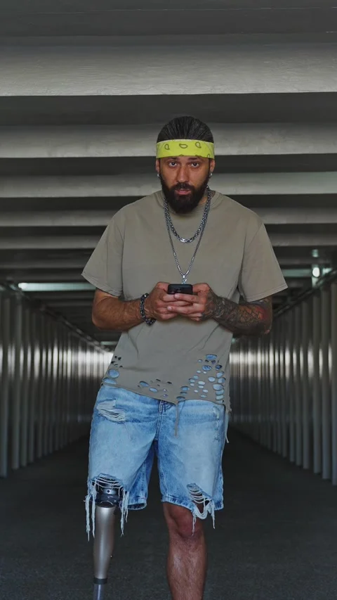 Young man using smartphone while standing in an industrial corridor at dusk Stock Footage 291962589