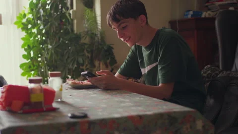 Young man using smartphone while having breakfast at home Stock-Footage 311567355