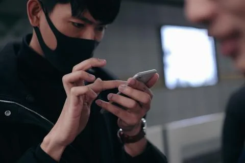 Young man using smartphone while waiting for subway Fotos Stock