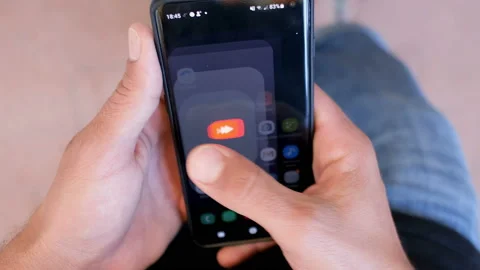 Young man using smartphone youtube app,browsing digital video platform Stock Footage 137759897