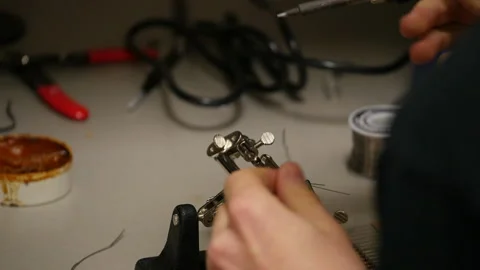 Young man using a soldering iron Stock Footage 147359921