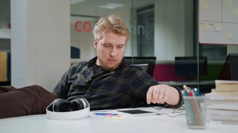 A Young Man Using a Tablet and Listening to Music Stock Footage 86296391