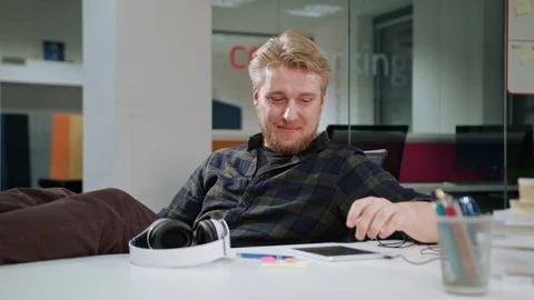 A Young Man Using a Tablet and Listening to Music Stock Footage 86296620