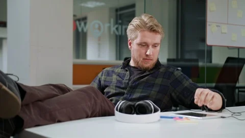 A Young Man Using a Tablet and Listening to Music Stock Footage 86297294