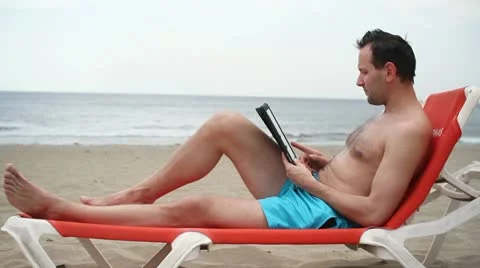 Young man using tablet computer on the beach HD Stock Footage 10868062