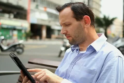 Young man using tablet computer in the city NTSC Stock Footage 10881820