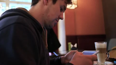 Young man using tablet computer in cafe Stockbeeldmateriaal 61520111