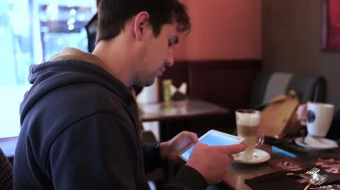Young man using tablet computer in cafe 스톡 동영상 61520181