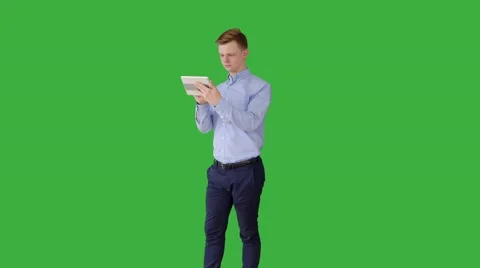 Young man using tablet computer searching the web isolated on green-screen Stock Footage 62571867