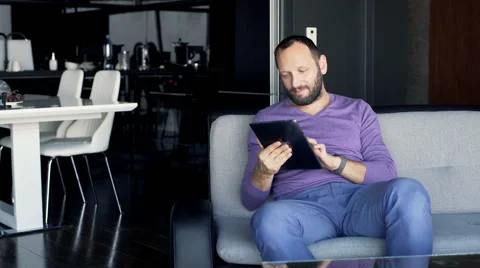 Young man using tablet computer while sitting on sofa at home Stock-Footage 63220966