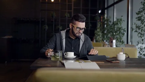 Young man using tablet computer and drinking tea in cafe Stock Footage 99249058