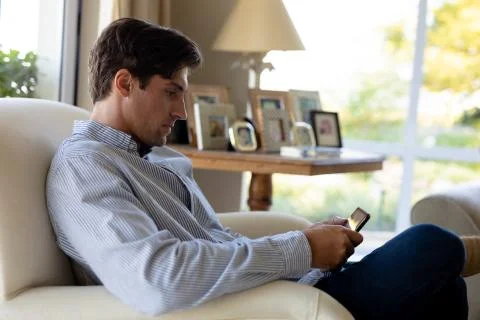 Young man using tablet computer on sofa at home 스톡 사진