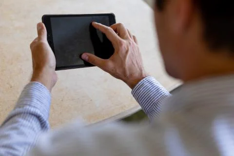 Young man using tablet computer on sofa at home 스톡 사진