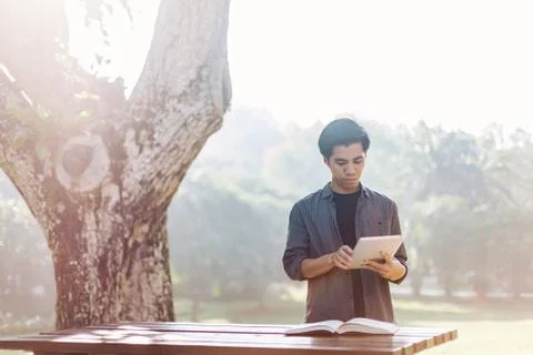 Young man using tablet device in a park 스톡 사진